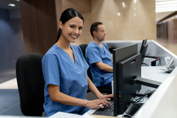 Happy receptionist working at a hospital Happy Latin American receptionist working at a hospital and looking at the camera smiling - healthcare concepts secretary stock pictures, royalty-free photos & images