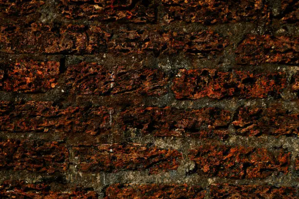 Old laterite wall laterite texture background,Pattern decorative uneven cracked real stone wall surface with cement