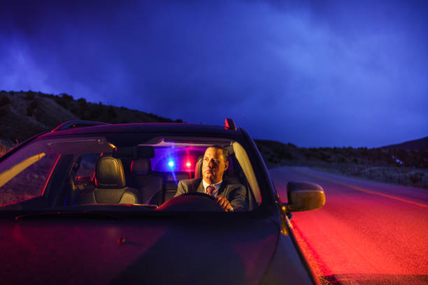 Professional Man in Suit Being Pulled Over by Police Professional Man in Suit Being Pulled Over by Police - Night dusk scene with car along highway being pulled over by police. Professional man wearing sport coat and tie in SUV. driving under the influence stock pictures, royalty-free photos & images