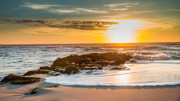 ロングビーチ島の泡に覆われた桟橋の日の出 - lbi ストックフォトと画像