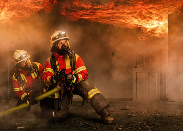istock Two firefighters in a burning house 1213910365