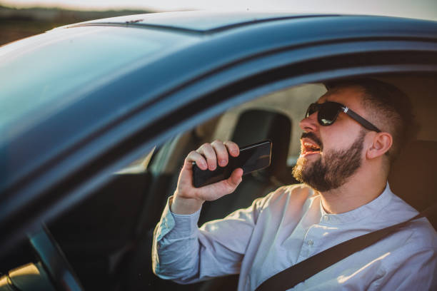 A man sings in a car