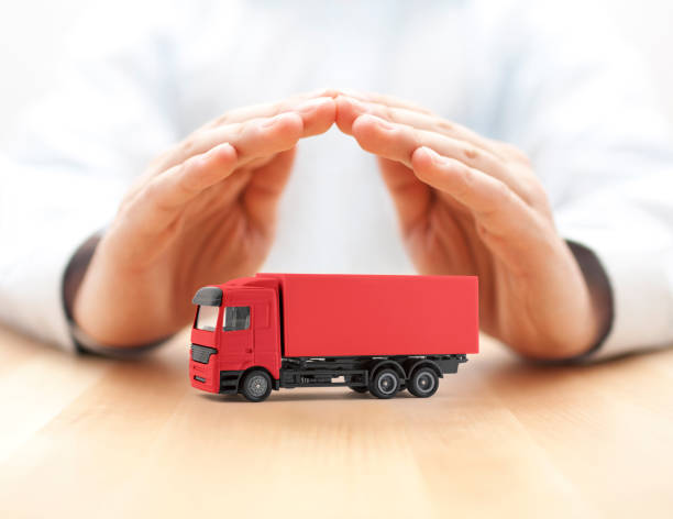 istock Red cargo delivery truck protected by hands 1213911143