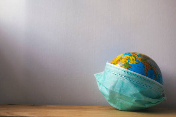 istock World globus with green medical mask on it 1213911595