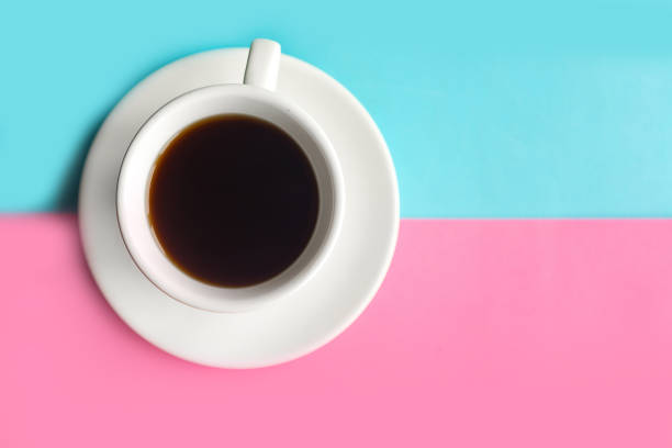 istock Coffee cup on blue and pink pastel background. Minimal concept 1213912386