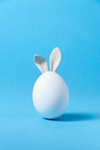 istock Easter Egg with Bunny Ears on Blue Background. Creative Greeting Card. Minimalism Concept. Copy Space 1213912409