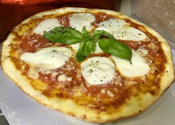 istock Round pizza with tomato and cheese 1213913845