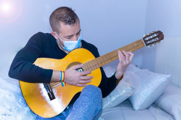 istock young man playing guitar with gay pride bracelet 1213913938