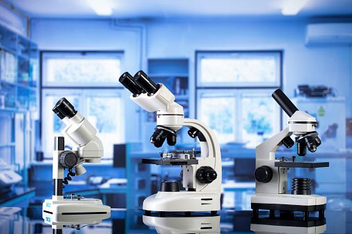 Modern scientific laboratory interior. Reaserch station with microscopes on the glass table