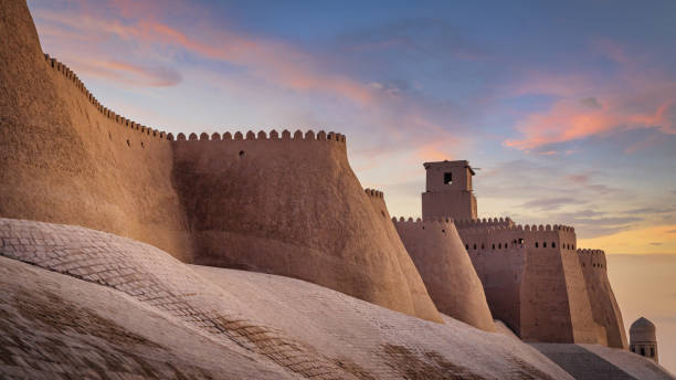 Ancient City Walls of Khiva Uzbekistan in Sunset Twilight Majestic ancient historic city walls of the old town of Khiva under beautiful colorful sunset twilight. Ancient City Walls Khiva, Itchan Kala, Khiva - Chiva - Хива, Xorazm Region, Uzbekistan, Central Asia fortified wall stock pictures, royalty-free photos & images