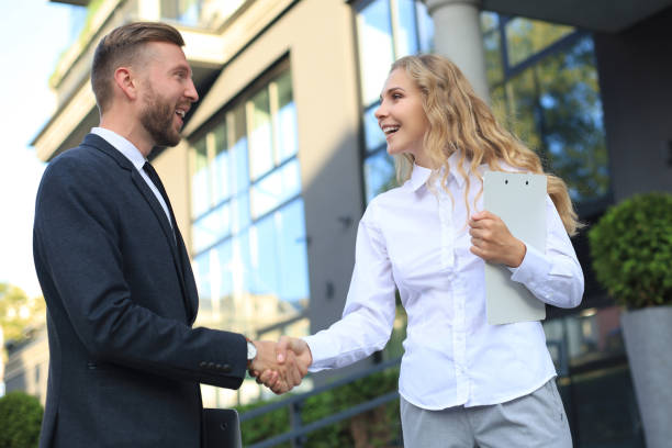 istock Image of collegues discussing documents and shaking hands near office. 1213917419