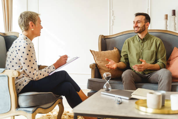 istock High-spirited man smiling at his female psychoanalyst 1213917673