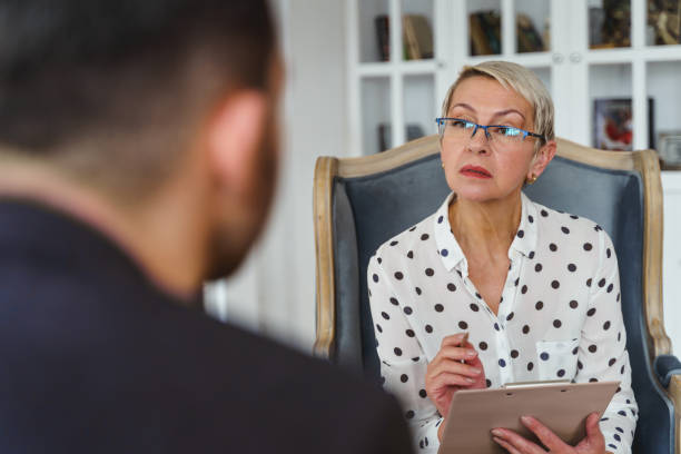 istock Psychoanalyst with a pen staring at a man 1213917883