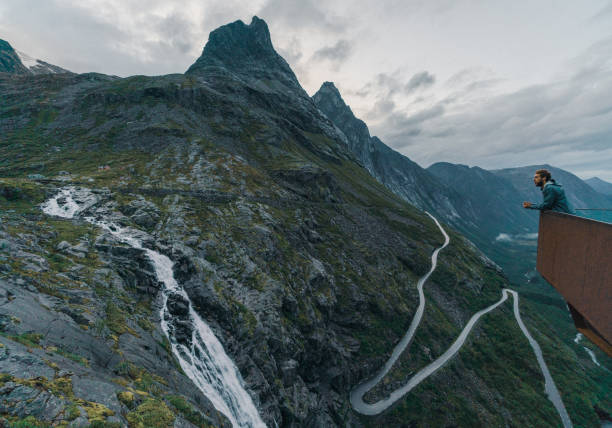 istock Man looking at  Trollstiegen in fog 1213919382