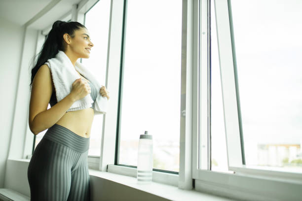 istock Sporty woman looking thought to window 1213920337