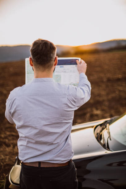 istock Young businessman exploring the  map in the car 1213922834