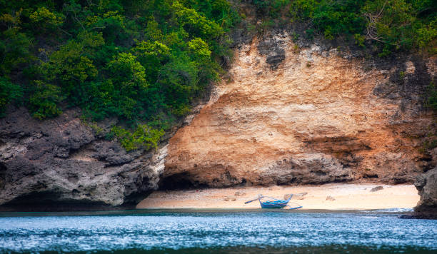 piccola barca tradizionale su una spiaggia nascosta vicino a puerto galera a mindoro, filippine - puerto galera foto e immagini stock