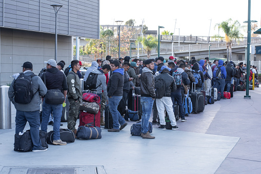 San Ysidro, California, USA - March 20, 2020: Migrant workers from Mexico wait for transportation to seasonal work destinations before potential border closing due to the pandemic.