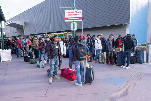 San Ysidro, California, USA - March 20, 2020: Migrant workers from Mexico wait for buses to transport them to seasonal work destinations before potential border closing due to the pandemic.
