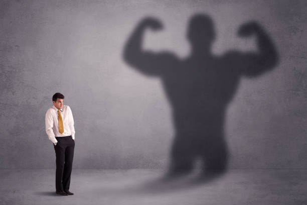 istock Business man looking at his own strong fit shadow concept 1213926011