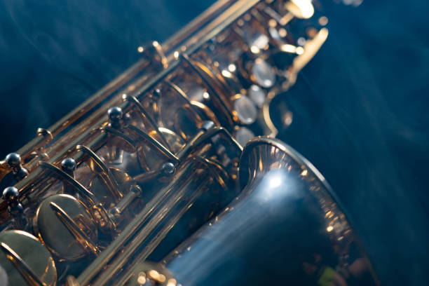 istock Golden shiny alto saxophone on black background with smoke. copy space 1213929800