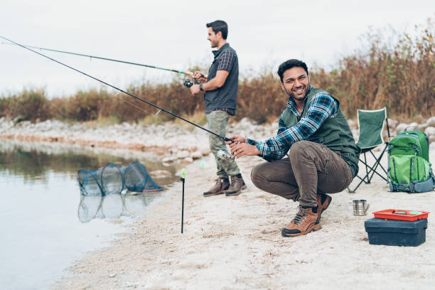 istock Fishermen holding rods by a lake 1213930068
