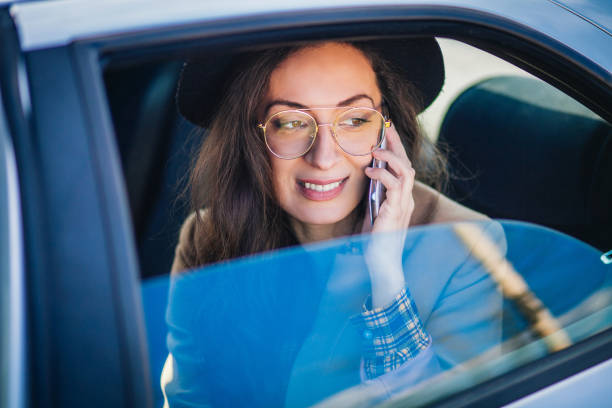 женщина, используя мобильный телефон в автомобиле - car phone стоковые фото и изображения