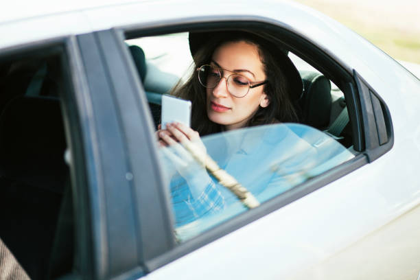 женщина, используя мобильный телефон в автомобиле - car phone стоковые фото и изображения