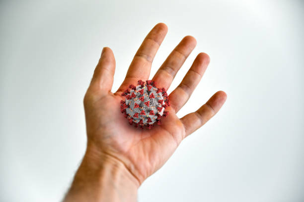 istock Hand holding big Coronavirus COVID-19 in palm. 1213936322