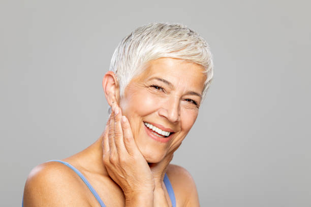 istock Happy senior woman against grey background. 1213936600