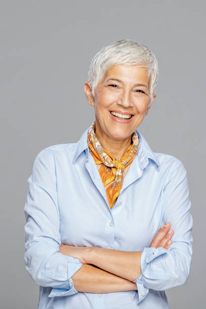 istock Happy senior woman against grey background. 1213936610