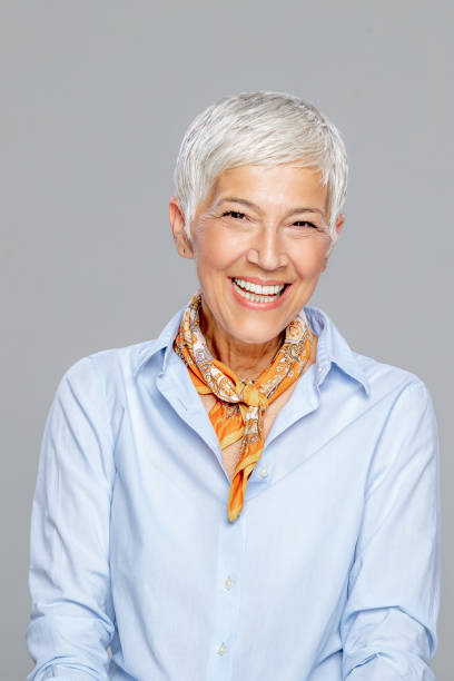 istock Happy senior woman against grey background. 1213937168