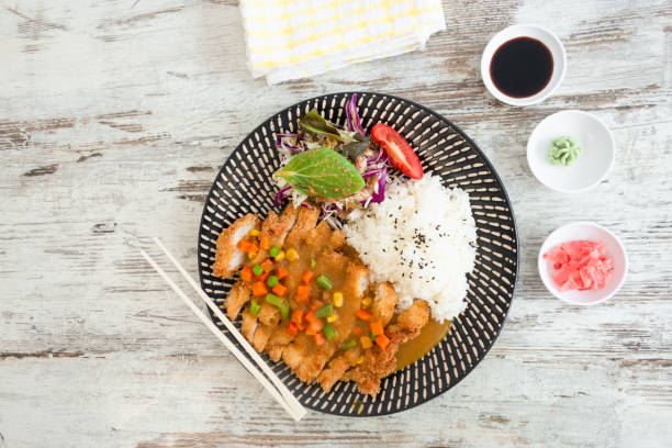 Curry Chicken Don. Curry chicken don with rice an salad table top view. sticky sesame chicken sauces stock pictures, royalty-free photos & images