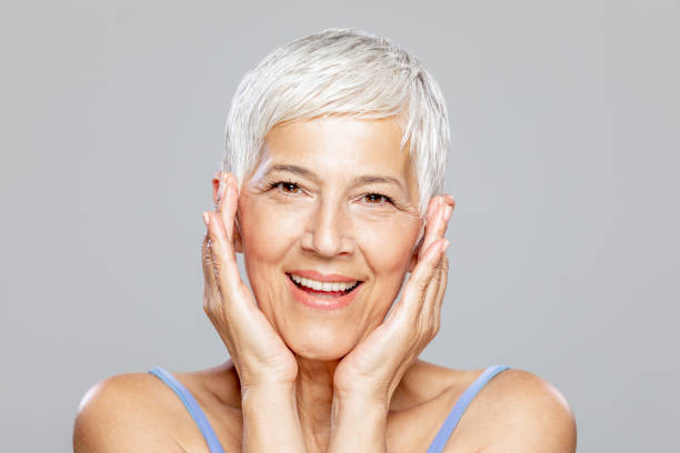 istock Happy senior woman against grey background. 1213937468