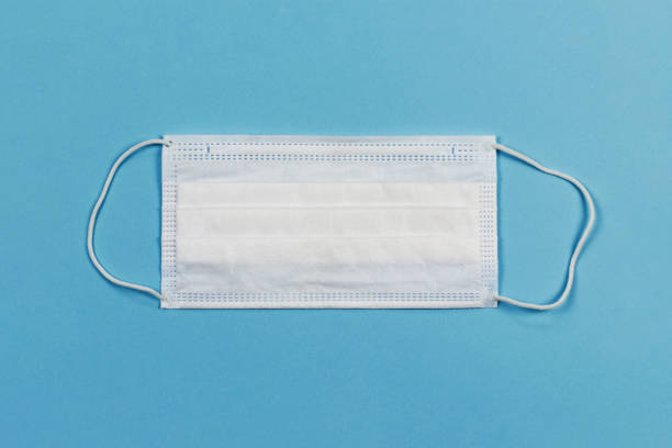 istock disposable face mask against virus, on blue background 1213937584