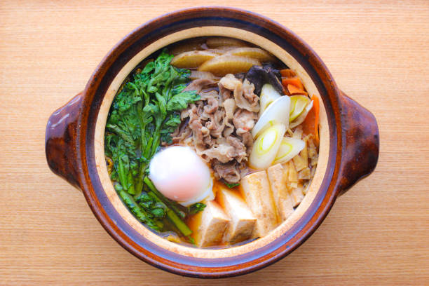 Sukiyaki Sukiyaki/Japanese Beef Hot Pot Sukiyaki（すき焼き） is a hot pot dish made from meat, tofu, long green onion, and other vegetables, simmered in a salty-sweet sauce. crown daisy stock pictures, royalty-free photos & images