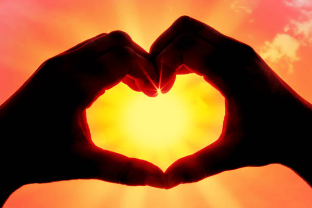 istock Hands forming a heart shape over the sun 1213943949