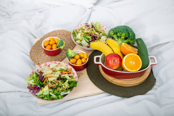 healthy healthy breakfast with fruit in bed - strawberry blueberry raspberry glass imagens e fotografias de stock