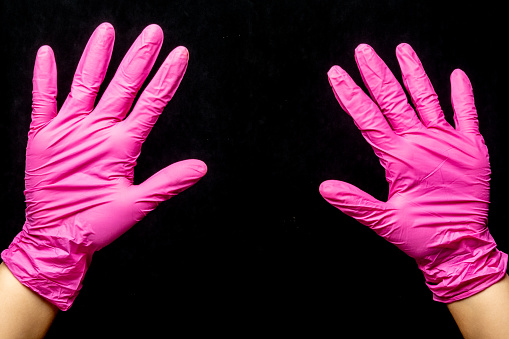 Women's hands dressed in latex glove waving and prepared for a hygiene of the environments. \nA gesture of bye or even a simple greeting movement.