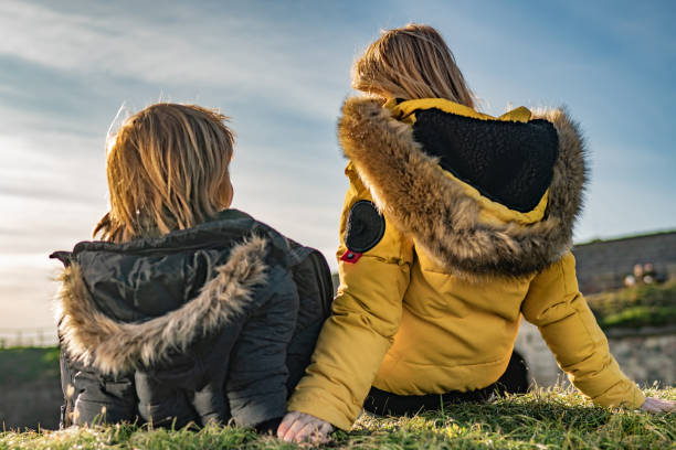 istock Rear view boy with mom sits on the grass 1213949013