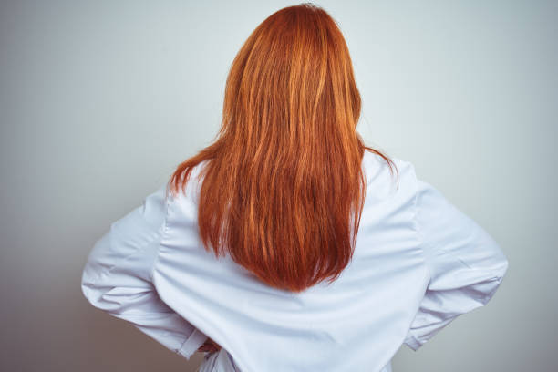 istock Young redhead doctor woman using stethoscope over white isolated background standing backwards looking away with arms on body 1213949787