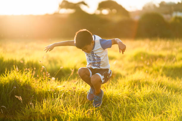 istock Kid in field jumping on grass. 1213956741
