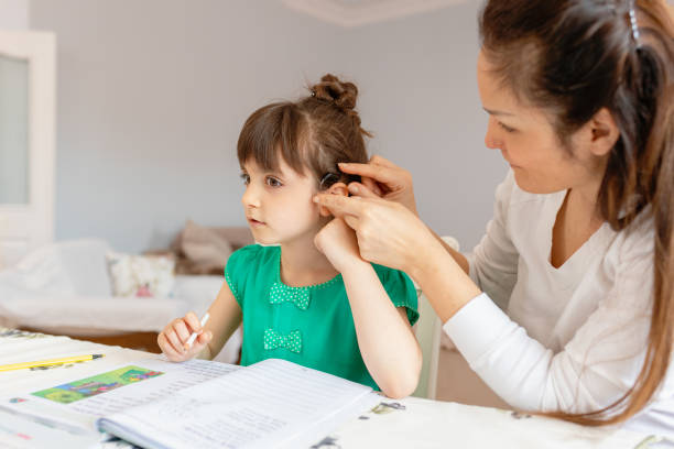Mother helping daughters with homework Mother helping daughters with homework deafness photos stock pictures, royalty-free photos & images