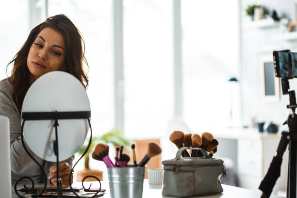 istock Beauty blogger putting on face make-up on live stream 1213960545