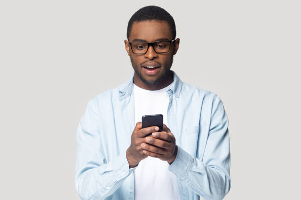 istock Head shot surprised African American man looking at phone screen 1213961246