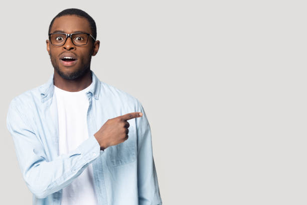 istock Surprised African American man with open mouth pointing to aside 1213961255