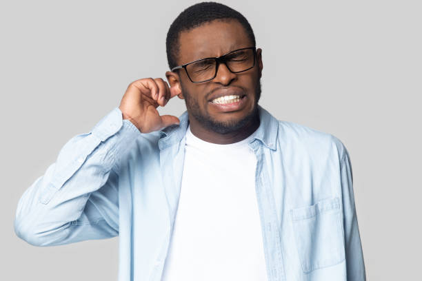 istock Head shot unhappy annoyed African American man plugging ear 1213961292