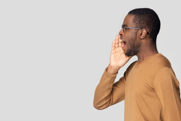 istock African American man speaking loud, shouting aside at copy space 1213961357