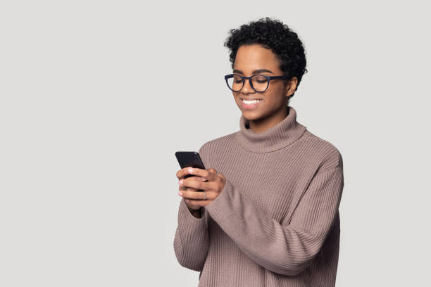 istock Smiling African American woman in glasses using phone, having fun 1213961459