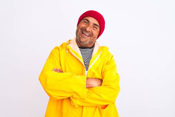 istock Middle age man wearing rain coat and woolen hat standing over isolated white background happy face smiling with crossed arms looking at the camera. Positive person. 1213967907